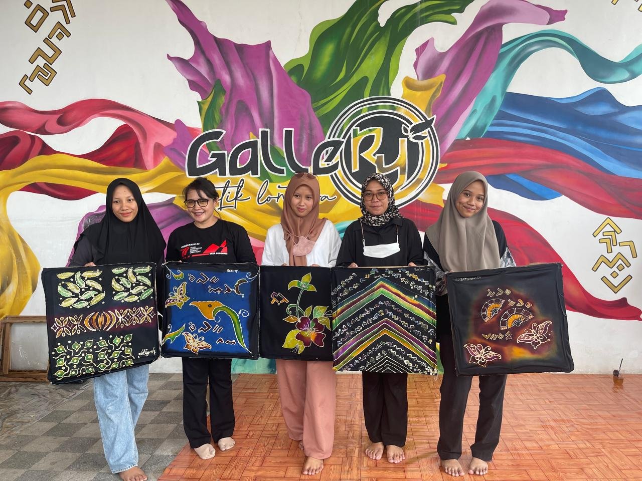 Peserta pelatihan membatik memamerkan hasil karya batik di depan mural Gallery Batik Lontara